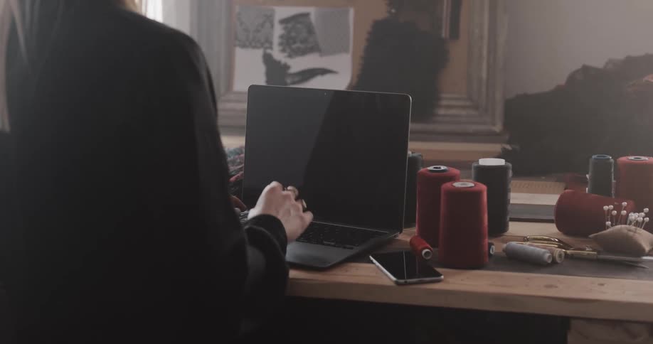 A woman is typing on the laptop