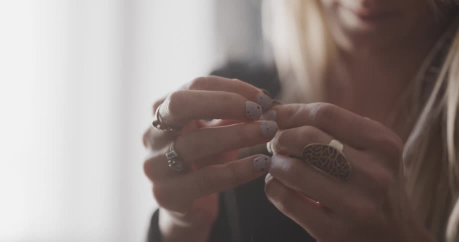 A woman is fixing her nails on her hand