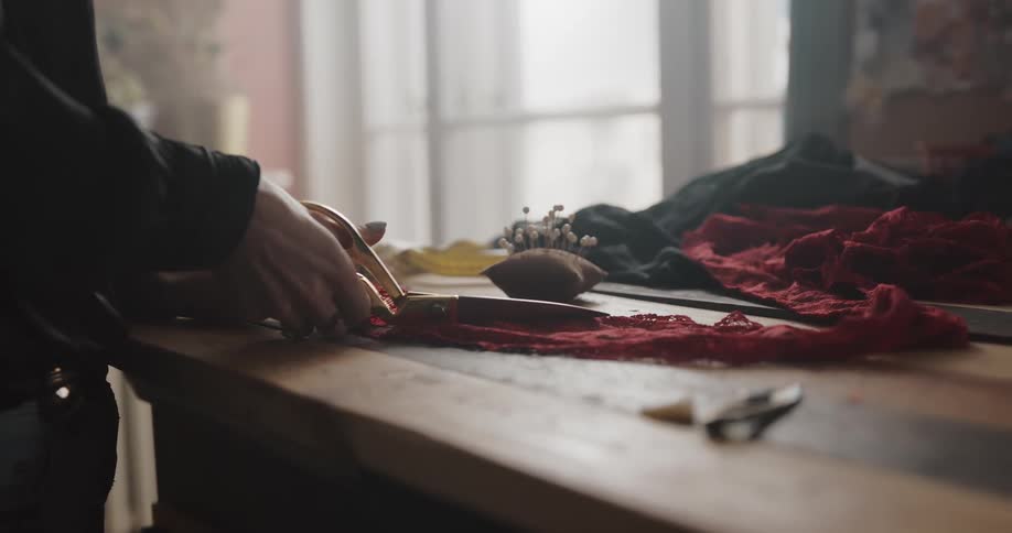 A person is cutting pieces of fabric with a scissors
