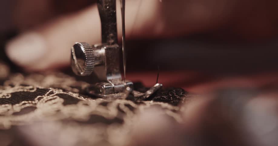 Close up of fabric going sewing machine foot while being sewn