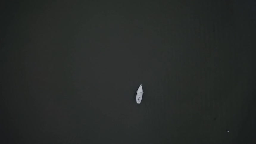 A white boat travels across the water
