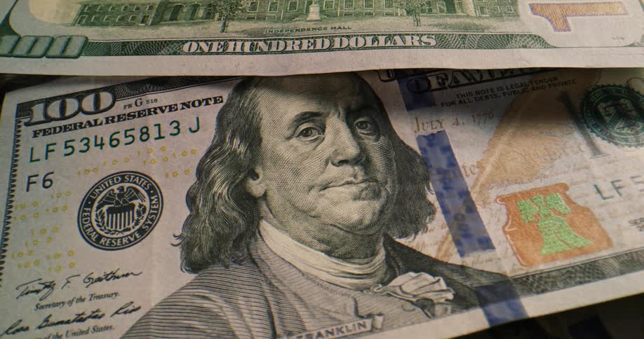 Two one hundred dollar bills one face up the other face down