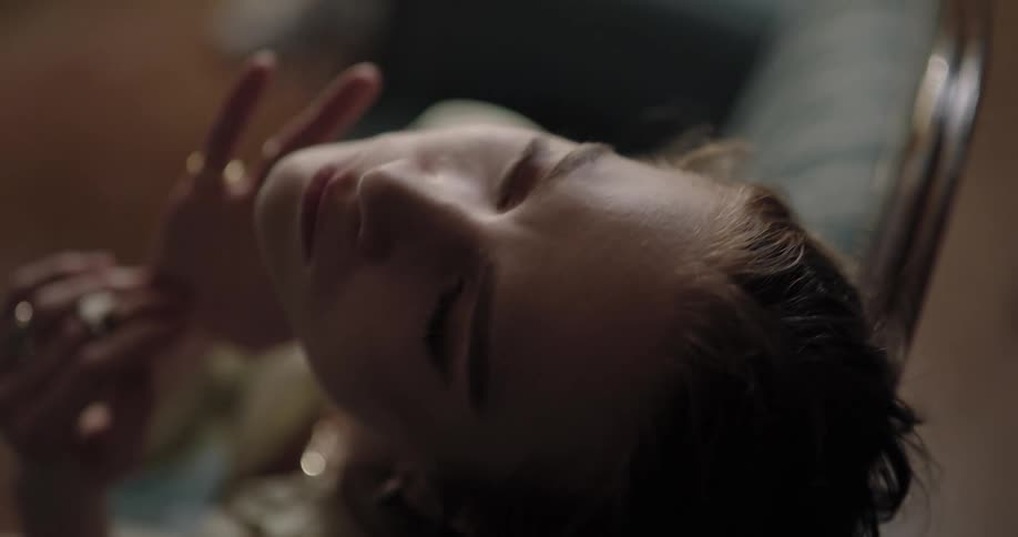A woman is resting and sitting on a couch
