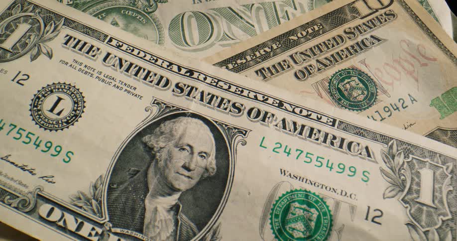 George washintons face is on a dollar bill as it sits on top of other paper money