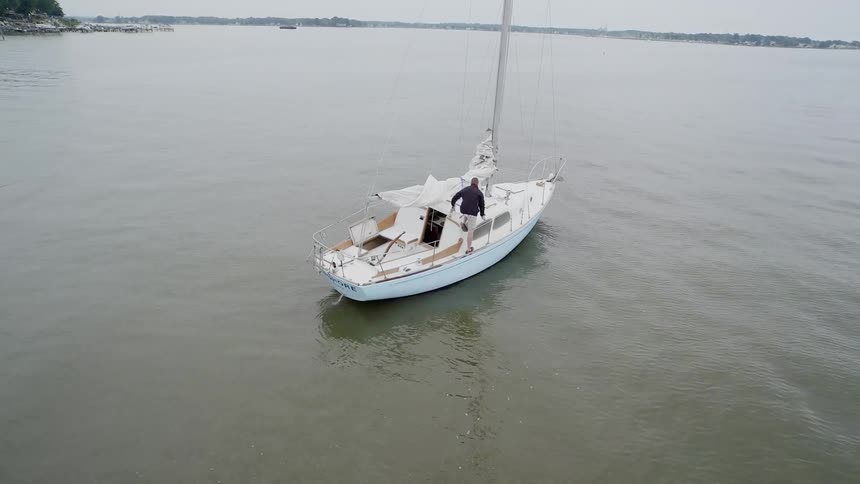 A man is on a sailboat
