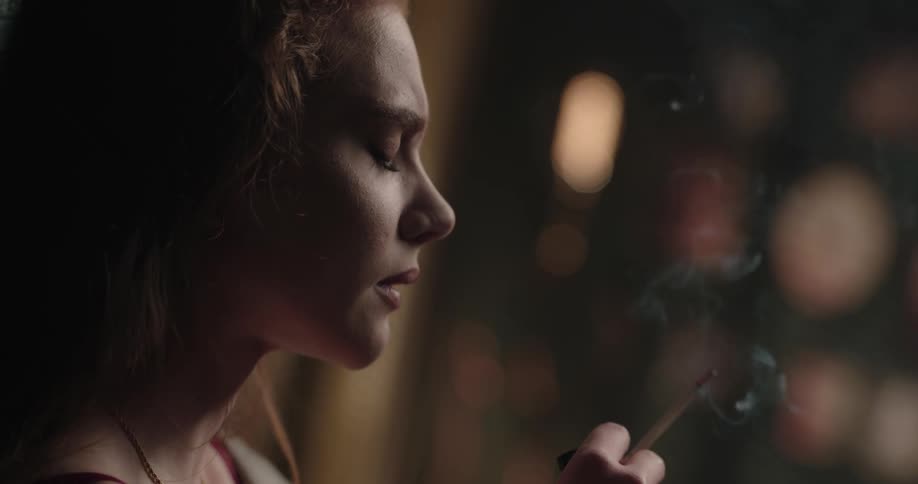 A woman is smoking a cigarette in a room