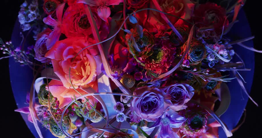 Colorful elaborate floral arrangement sits on purple table