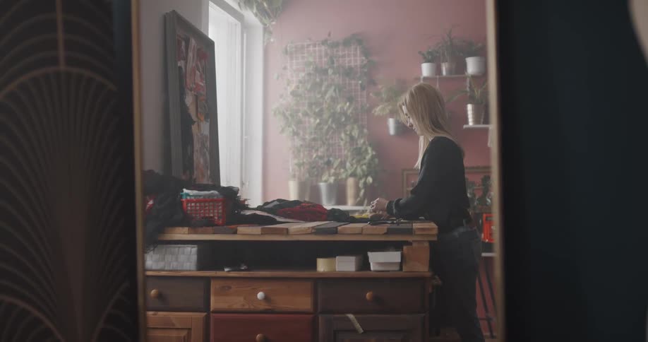 A woman is putting clothes away in her bedroom