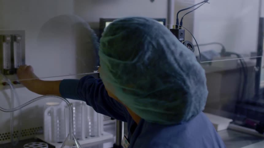 A nurse attaches a hose to a meter on a wall