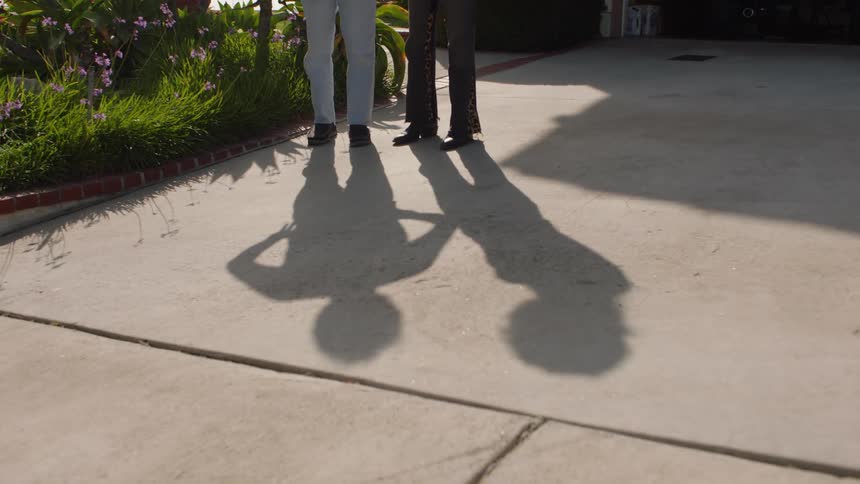 Shadows of two people talking in the driveway