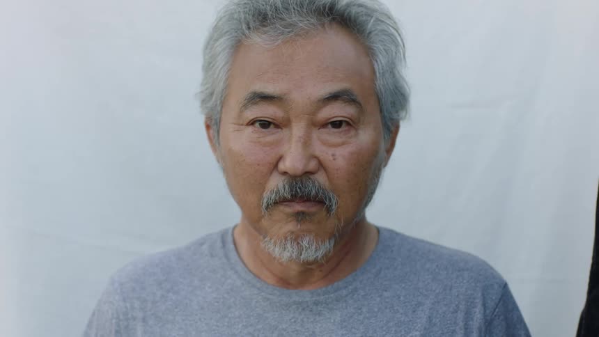 Close up of the face of an asian man looking at the camera