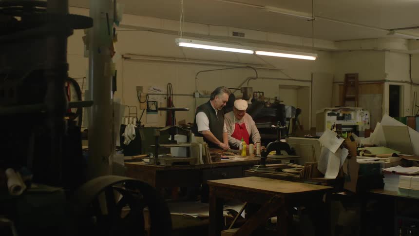 Two older men work together in workshop