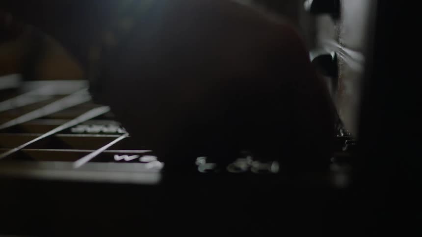 A hand reaches into printing press type tray and picks up letters