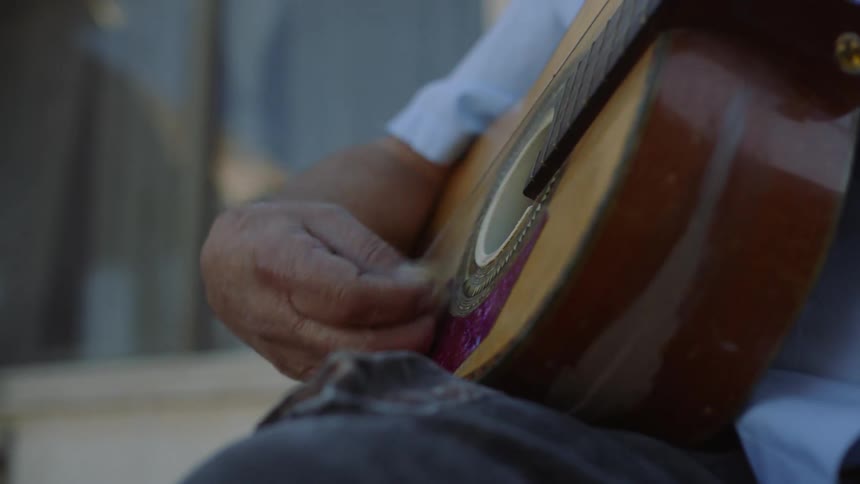 A person is playing the acoustic guitar