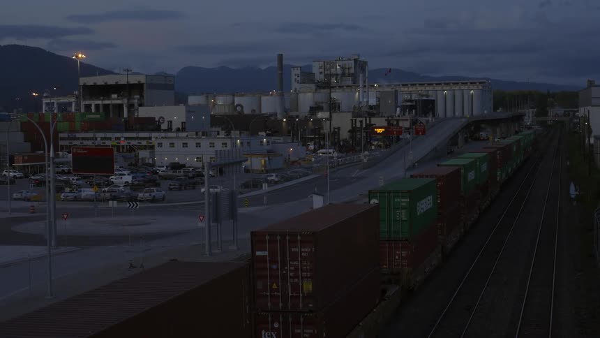 Containers lined up on a shipping yard terminal at evening