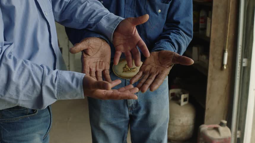 A man and his father stand with their hands palm up comparing them