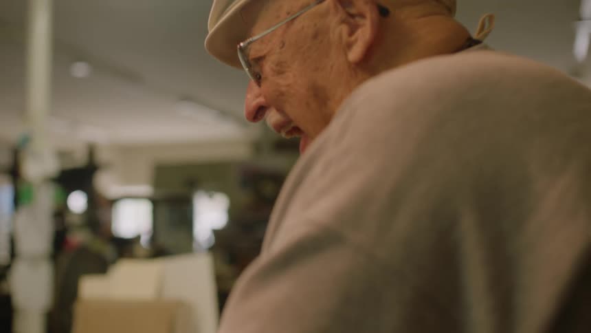 Elderly man laughing out loud in the living room at home