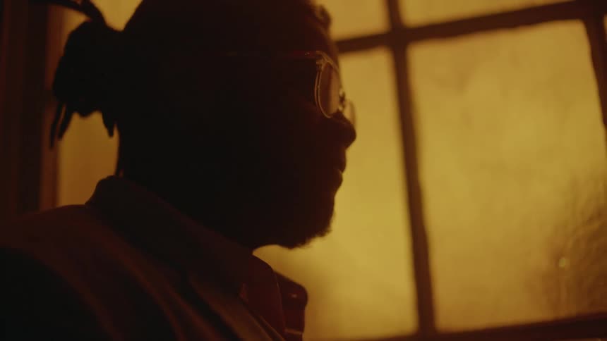 Close up of the silhouette face of a man standing in front of a window