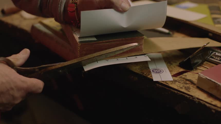 A person cuts the paper in the shop