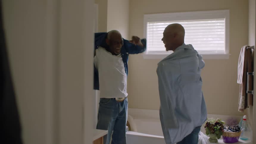 Father and son changing shirts in the bathroom at home