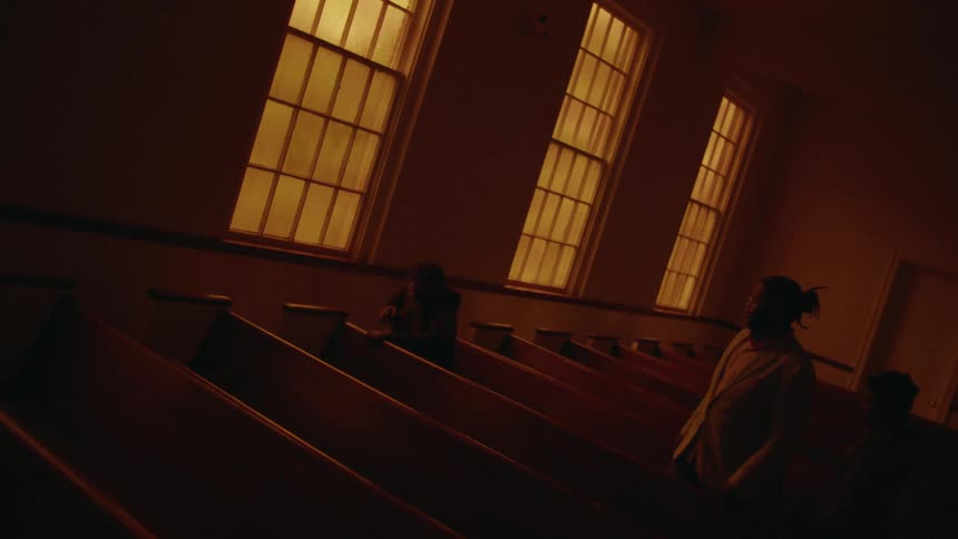 Man and sons enter pew and sit down near the aisle