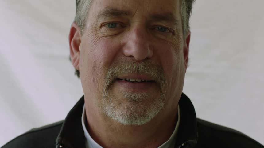 Face of an elderly man with gray hair and gray beard smiling