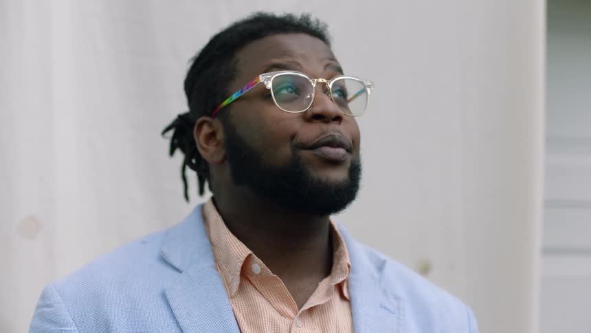 A man with glasses looks up