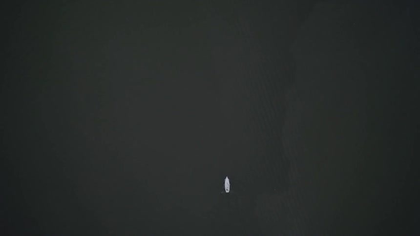 A small boat is moving in the water below