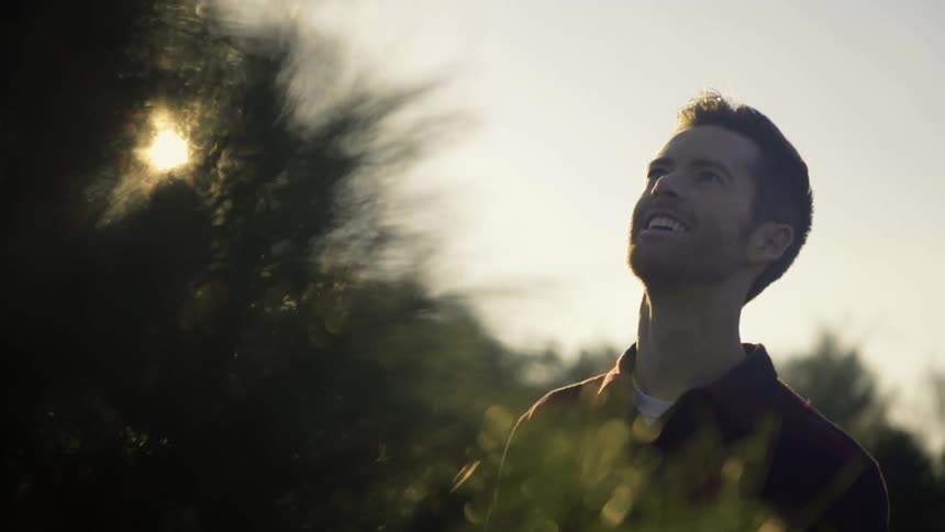 A man is looking at a tree with a smile on his face