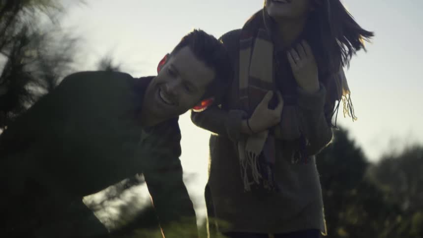 A couple are looking at a tree and smiling