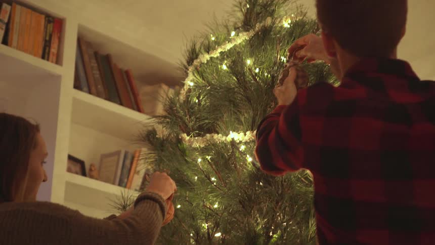 Man and woman decorate a christmas tree