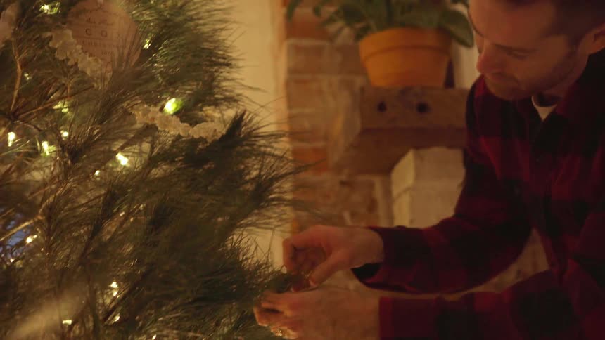 Man and woman decorate a christmas tree