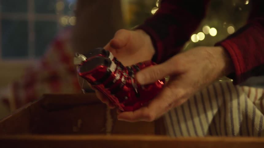 A man and woman decorate a christmas tree