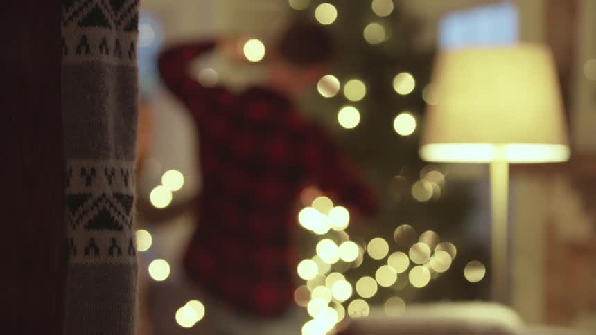 A man in a red flannel shirt is untangling christmas lights