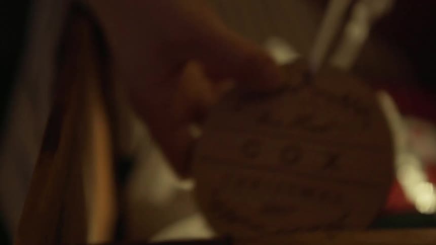 A woman is reaching into a box and pulling out christmas ornaments