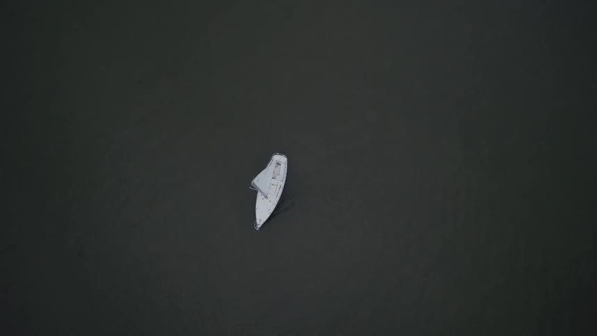 Sail boat traveling in the water below