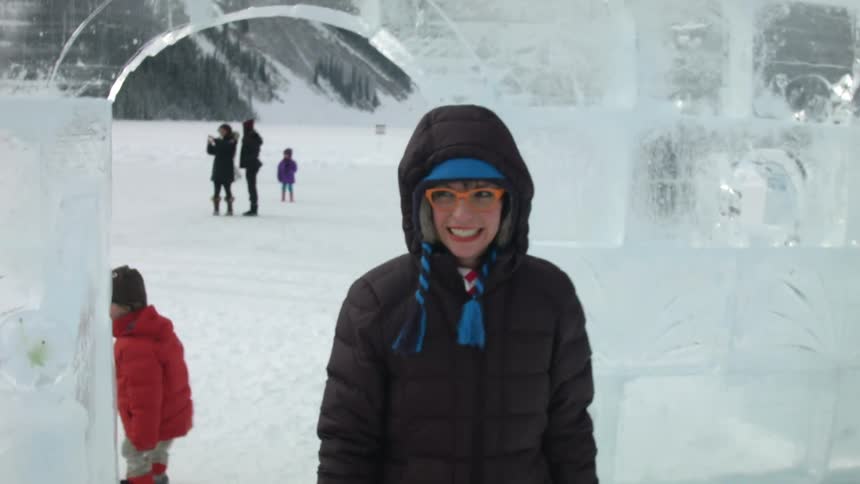 A woman carefully walks on ice and blows a kiss to someone