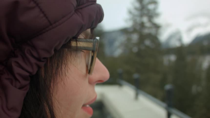 Woman with big glasses in a hooded jacket
