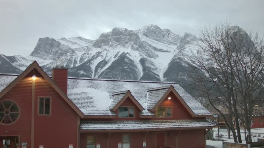 A red farmhouse or inn set in a snowy mountainous region
