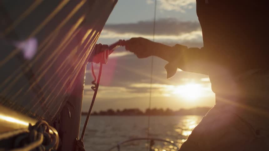 A man cranking a handle on a sailboat