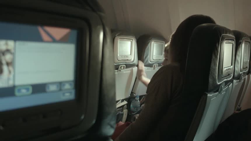 A child touches the screen on an airplane seat