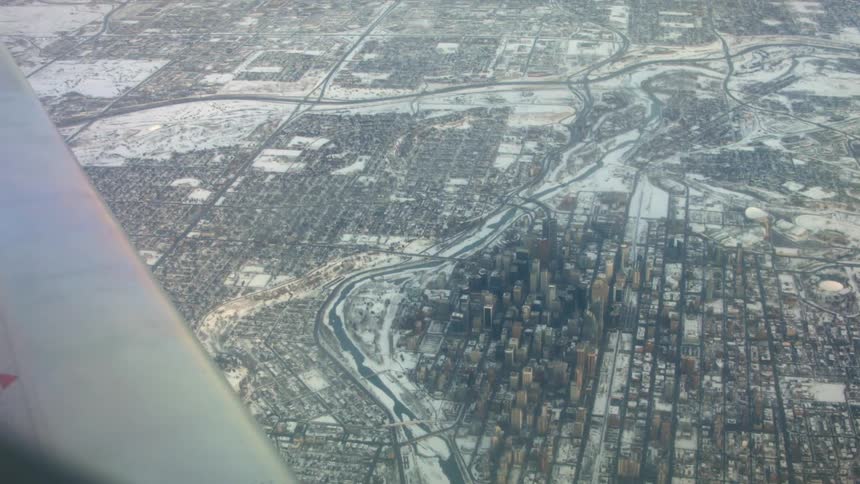 View from an airplane window showing a large city with skyscrapers below