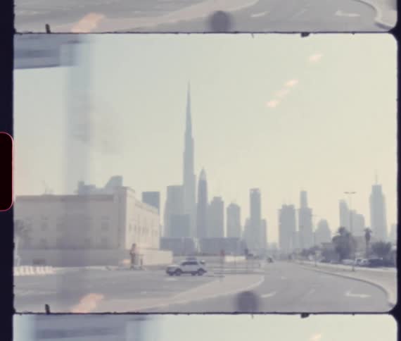 Vehicles drives through a neighborhood with views of downtown