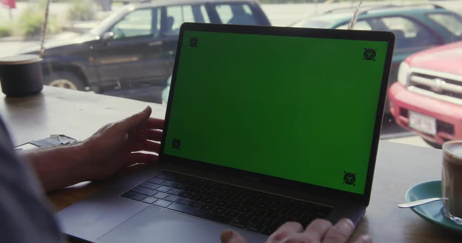 A person is sitting by the window using a laptop