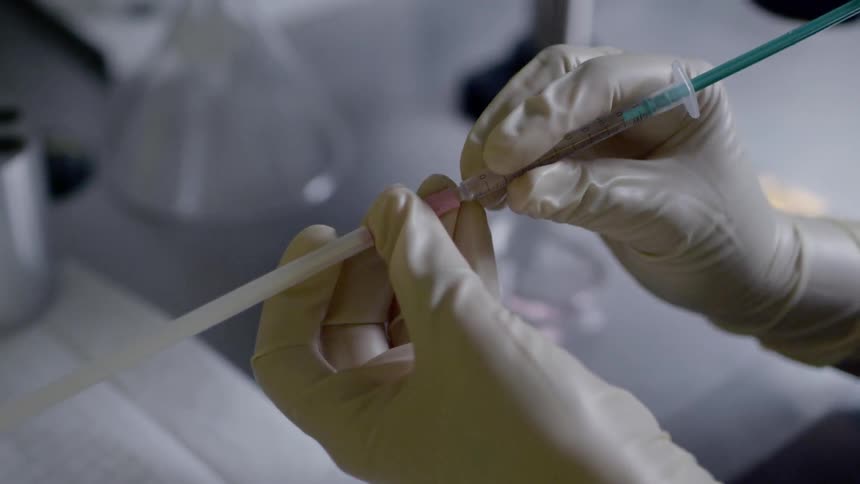 A person pushes liquid into a small pipe