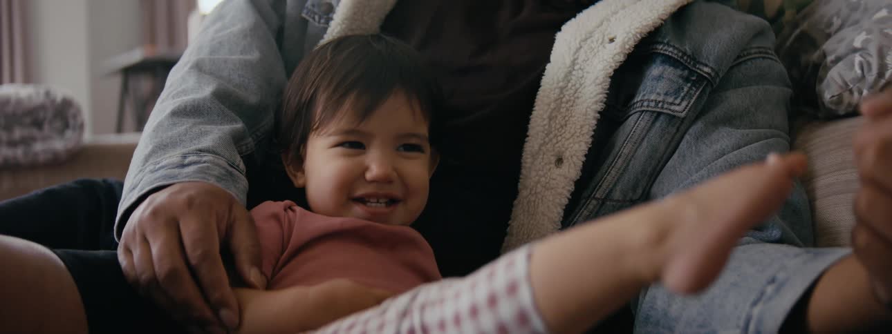 A toddler is hanging out with her parent and kicking there foot
