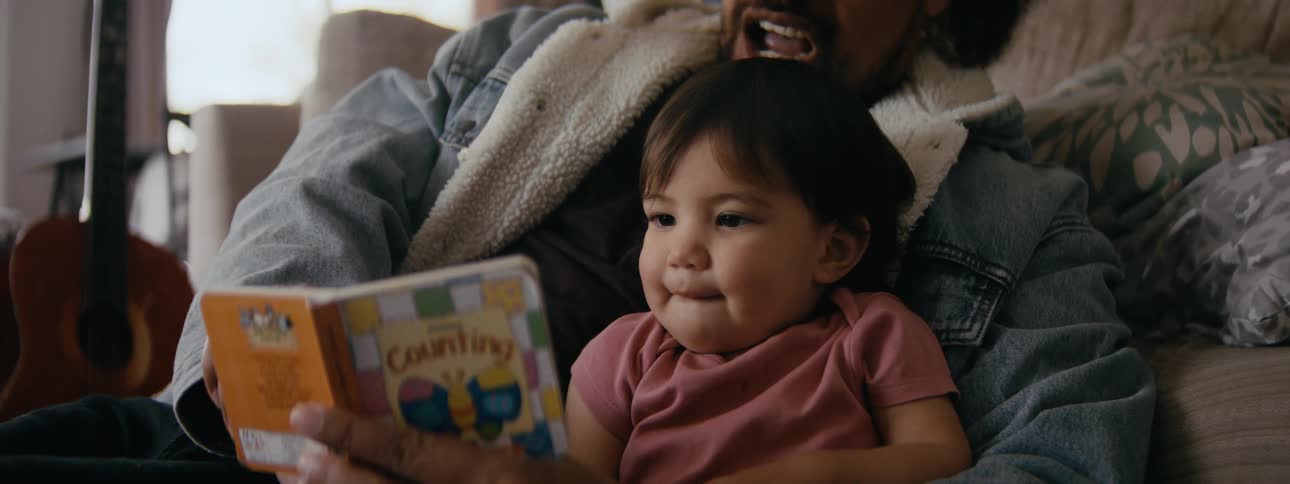 Father reads childrens book to his daughter