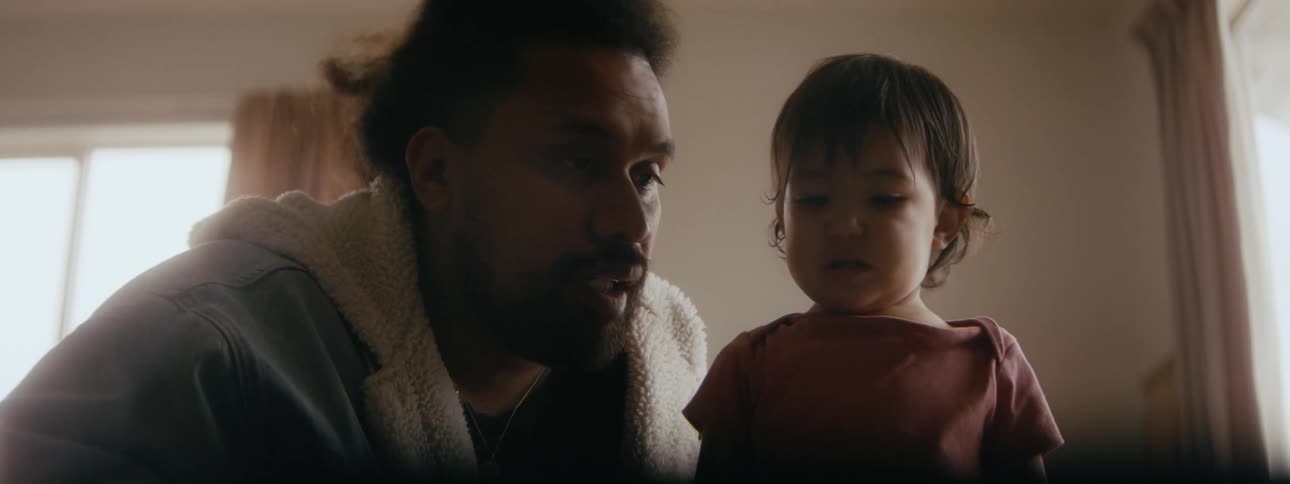 A father is reading a book to his daughter