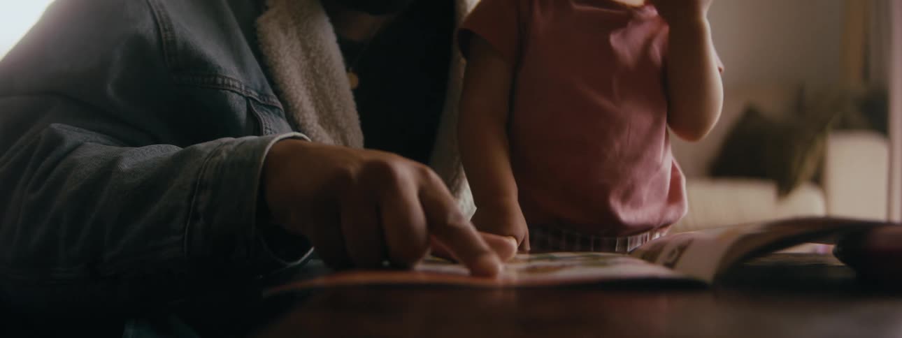 A father reading a book to their baby at home