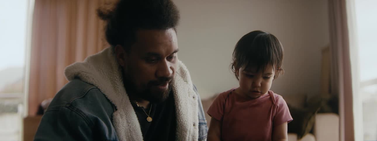 A father reading a book to his baby daughter